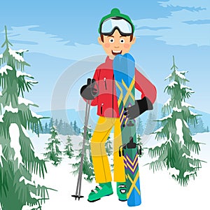 Young happy skier with ski poles poses in coniferous forest in mountains