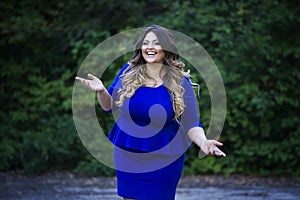 Young happy smiling beautiful plus size model in blue dress outdoors, xxl woman on nature photo