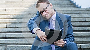 Young happy smiling business man working with tablet, horizontal portrait.
