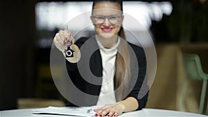 Young happy smiling business woman or real estate agent showing keys from new house. Isolated over background. Focus on
