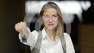 Young happy smiling business woman or real estate agent showing keys from new house. Isolated over background. Focus on