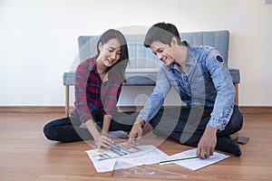 Young happy smiling couple choosing colors for painting their home,