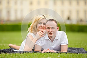 Young, happy and smiling couple lies on a grass