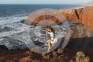 Young happy smiling couple in love on background of famous arch on Legzira beach