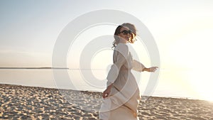 Young happy smiling girl walk on sea beach, enjoy carefree paradise island relax