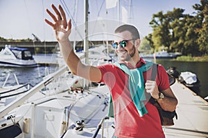 Young Happy Smiling Man in Glasses in Yacht Club.