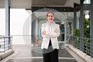 Young happy smiling professional business woman asian, happy confident positive female entrepreneur standing on street