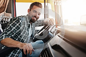 Young and happy smiling truck driver inside his vehicle