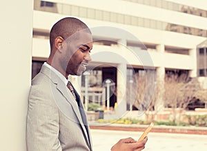 Young happy smiling urban professional man using smart phone