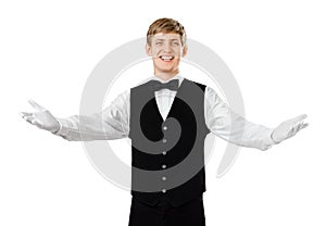 Young happy smiling waiter gesturing welcome