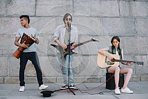 Young and happy street musicians band with guitars and djembe