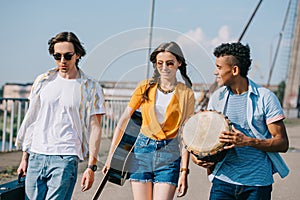 Young and happy street musicians carrying instruments