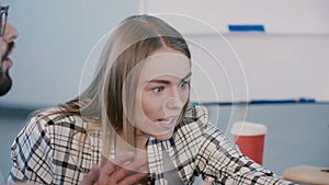 Young happy stressed confident European business woman discussing work, arguing with colleagues at office meeting table.