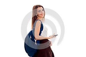 Young happy student girl with blue backpack posing isolated on white background in studio