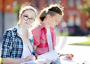 Young happy students with books and notes outdoors