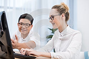 young happy students pointing on screen