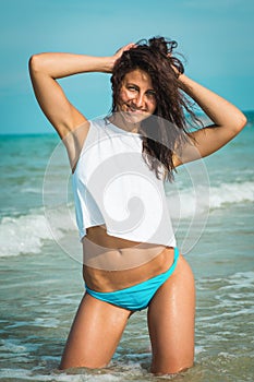 Young happy stylish caucasian female model on the sea shore.