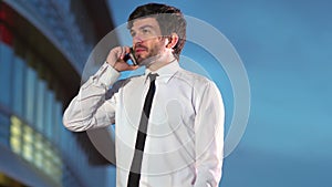 Young happy successful businessman talking on phone smiling.