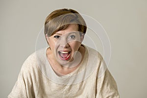 Young happy and surprised red hair woman looking to camera delighted astonished and in surprise face expression isolated on grey b