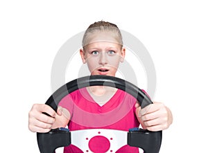 Young happy teenage girl in a pink t-shirt holding a car steering wheel in her hands, front view, isolated on white background.