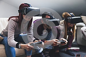 Young happy three friends playing video games virtual reality