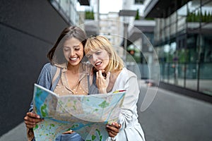 Young happy tourists friends women sightseeing in city on vacation