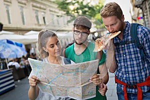 Young happy tourists sightseeing in city