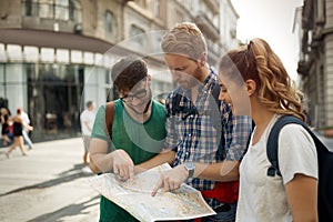 Young happy tourists sightseeing in city