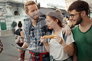 Young happy tourists sightseeing in city