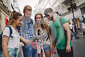 Young happy tourists sightseeing in city