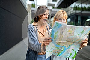 Young happy tourists women sightseeing in city on vacation