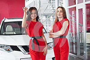 Young happy two woman near the car with keys in hand - concept of buying car