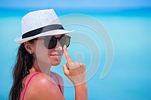 Young happy woman applying suntan lotion on her