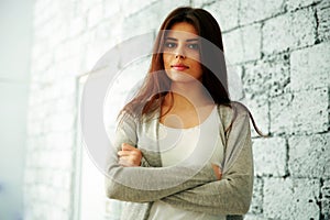 Young happy woman with arms folded standing