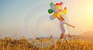 Happy woman with balloons at sunset in summer