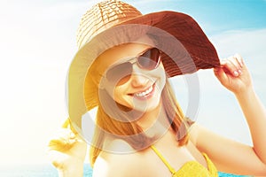 Mladý šťastný žena na pláž v slnečné okuliare a klobúk 