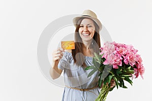 Young happy woman in blue dress, hat holding credit bank card, money, bouquet of beautiful pink peonies flowers isolated
