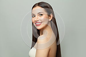 Young happy woman brunette with clear skin and long shiny straight hair on white background