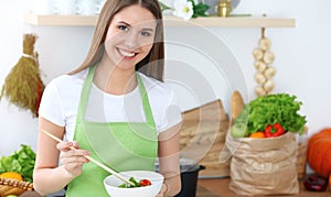 Young happy woman cooking in the kitchen. Healthy meal, lifestyle and culinary concepts. Good morning begins with fresh