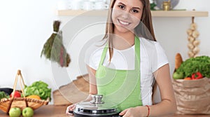 Young happy woman cooking soup in the kitchen. Healthy meal, lifestyle and culinary concept. Smiling student girl