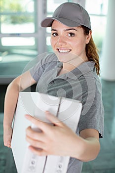 young happy woman courier with boxes in hands