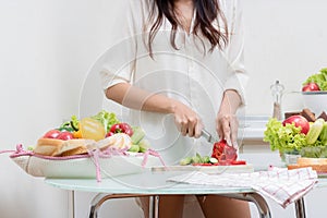 Young happy woman cutting vegetables