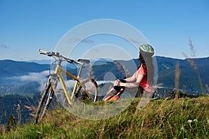 Young happy woman cycling on mountain bike at summer day