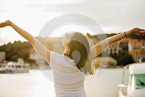 Young happy woman dancing under the sun.Happiness.Carefree female celebrating success.Romantic woman enjoying nature.Having fun.