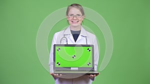 Young happy woman doctor showing laptop