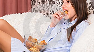 Young happy woman eating deep fried chicken, closeup. Woman eats chicken wings, calorie intake and health risks