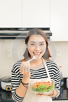 Young happy woman eating salad. Healthy lifestyle with green foo