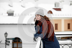 Young happy woman enjoying winter weather wearing scarf and knitted hat