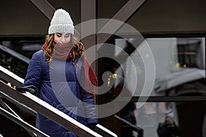 Young happy woman enjoying winter weather wearing scarf and knitted hat