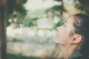 Young happy woman face smile with gum in nature take a deep breath feeling fresh. gums receding problem, oral dental care concept.